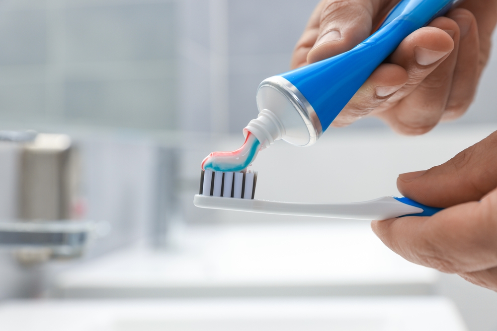 Human toothpaste on a toothbrush in the bathroom