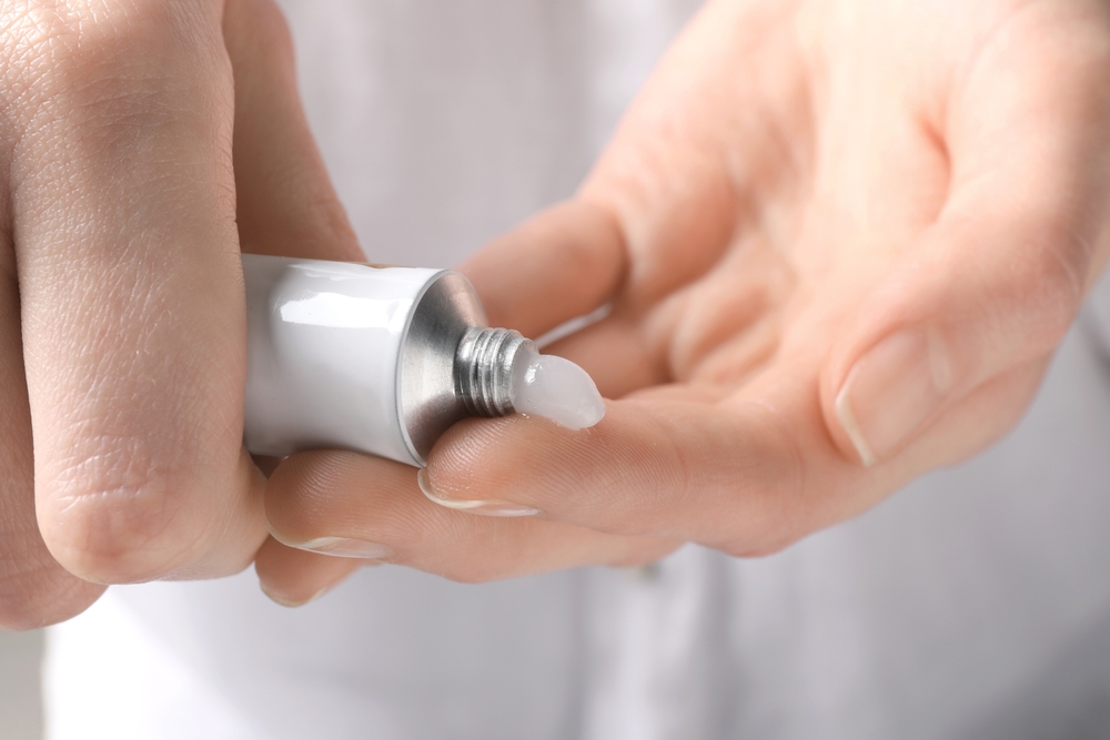 Woman squeezing out ointment from tube on her finger